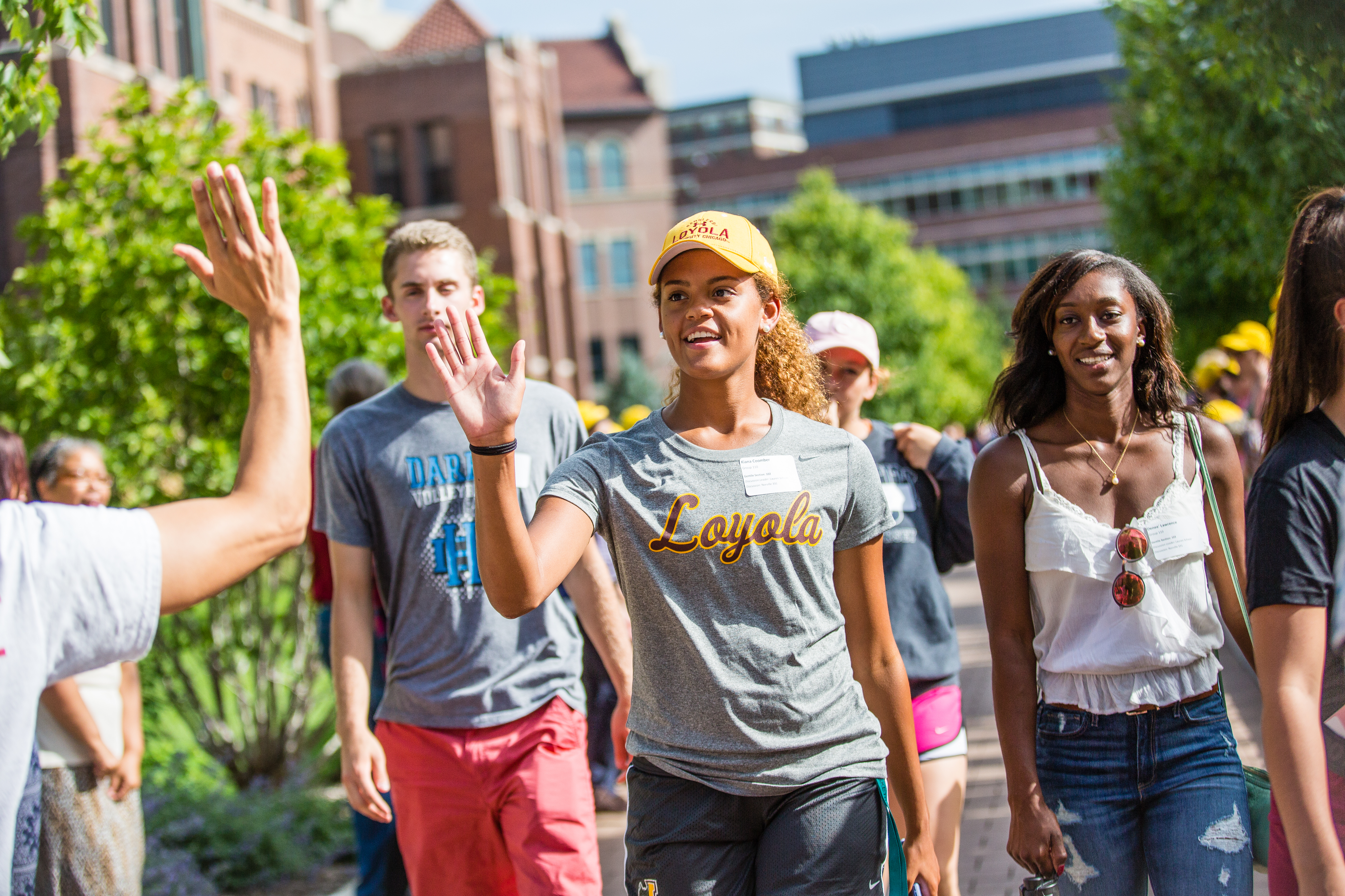 Photo shows new student in Loyola t-shirt giving a high five to another student.